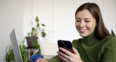 smiling customer looking at phone due to benefits of self service portal